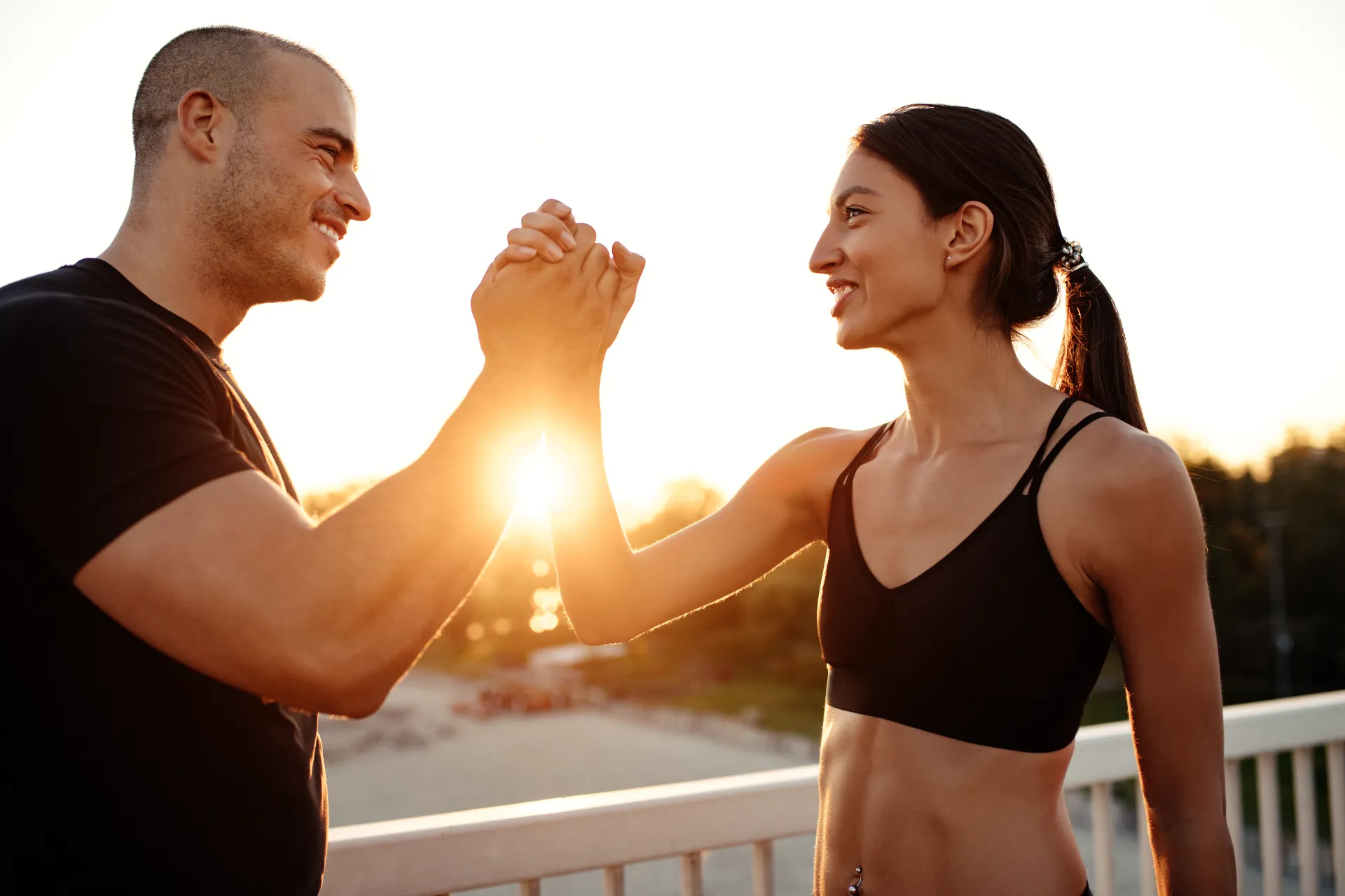 athletic woman and man giving each other high five utc