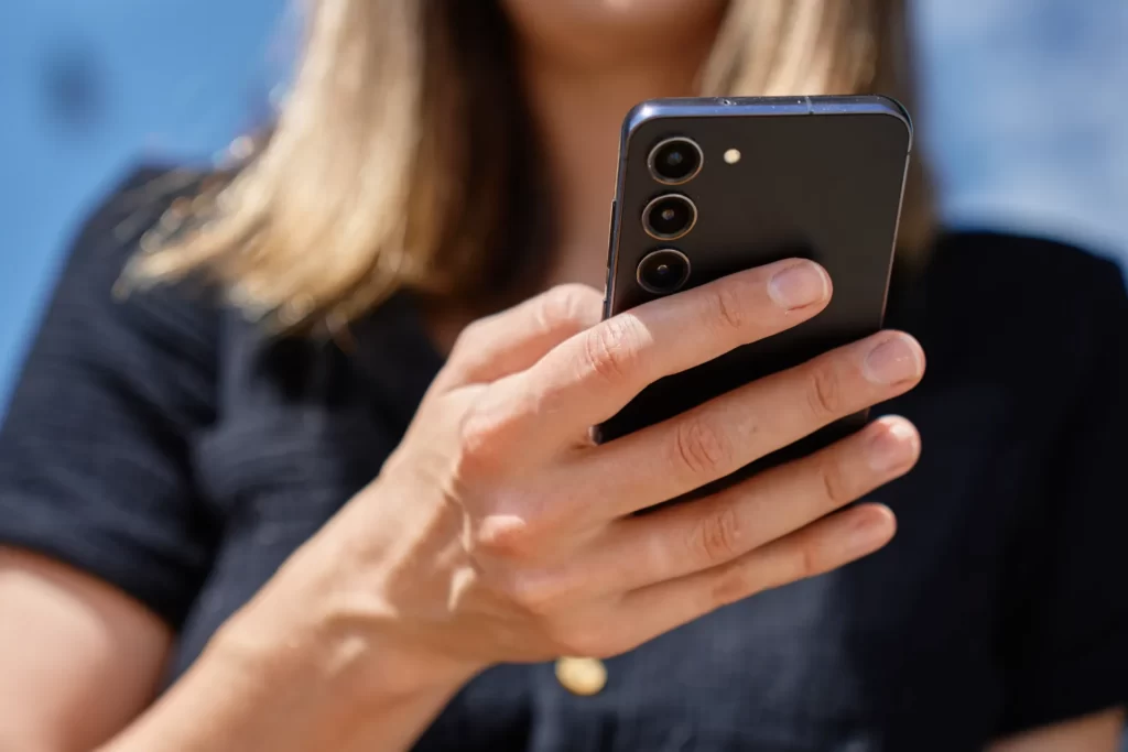 close up of woman holding smartphone in hand outdo utc